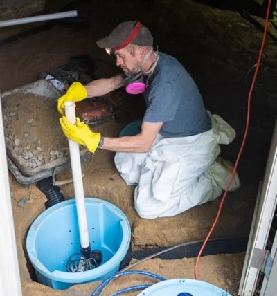 A Groundworks worker installing a sump pump.