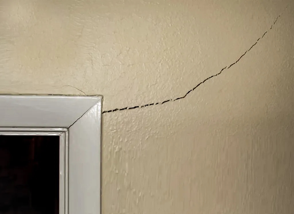 A corner crack next to a door frame in a home.