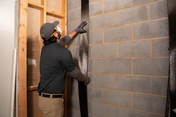 A worker installing Carbon Fiber in basement.