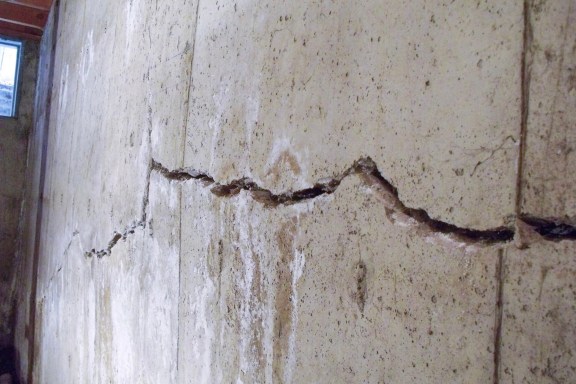 Close up of a crack in a bowing basement wall.