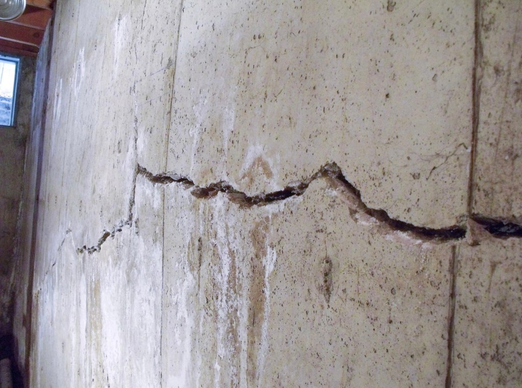 Close up of a crack in a bowing basement wall.