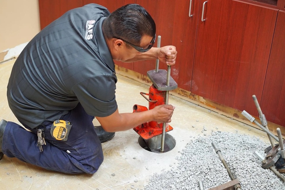 A worker completing a slab pier installation.