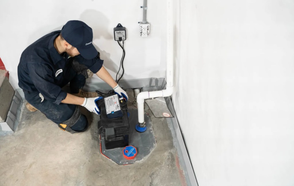 A worker installing a sump pump.