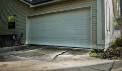 Cracked driveway at the base of the driveway by the garage door