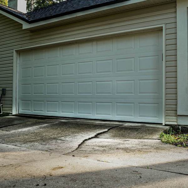 Cracked driveway at the base of the driveway by the garage door