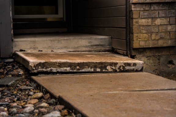 Front porch steps sinking on the exterior of a home.