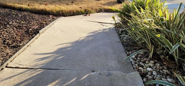 An uneven sidewalk on the exterior of a home.