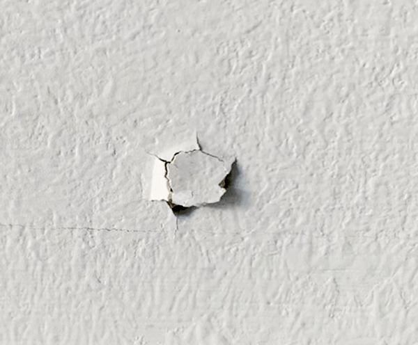 Close up of a drywall nail pop.