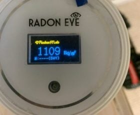 Close-up of a Radon Eye device displaying a radon gas level of 1109 Bq/m³ on its screen, emphasizing the urgent need for effective radon mitigation.