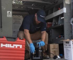 service tech inspecting a sump pump to see if it is running and shutting off when it is meant to turn off